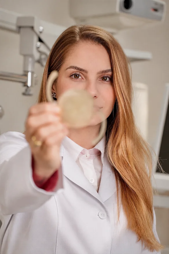 Dra. Isadora segurando a lente intraocular